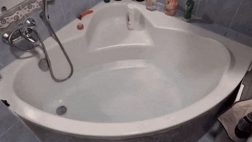 a bathtub in a bathroom with a bottle of pantene on the shelf