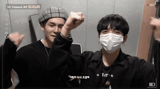 two young men wearing face masks are being recorded by a camera that says rec