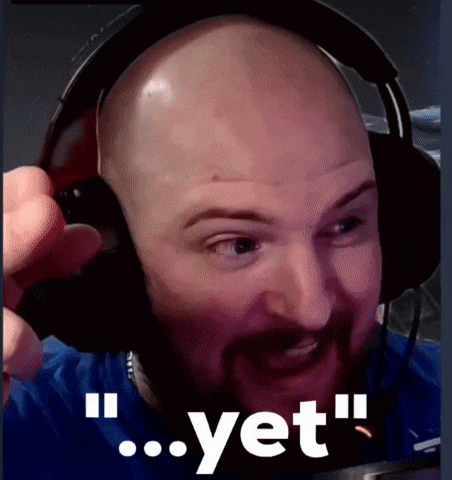 a bald man with a beard wearing headphones with the word yet behind him