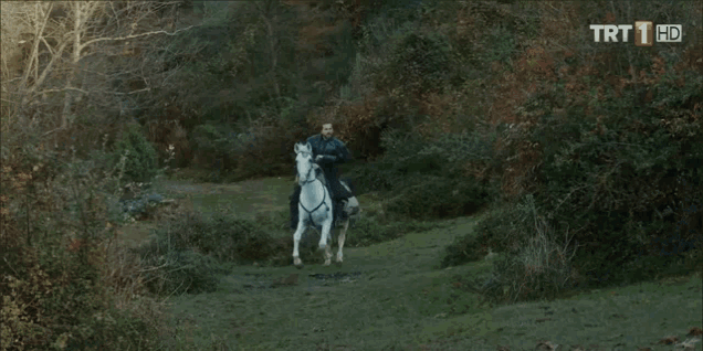 a man with a sword is riding a white horse with trt 1 hd in the corner