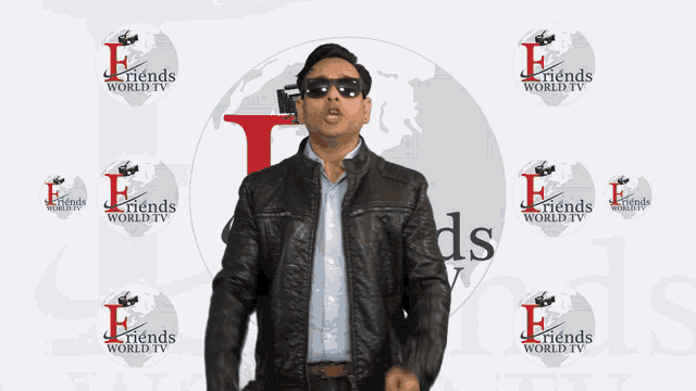 a man wearing sunglasses stands in front of a wall that says " friends world tv "