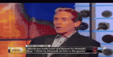 a man in a suit and striped shirt is talking on a television show