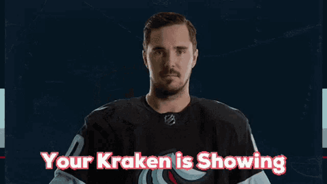 a hockey player is pointing at the camera with the words your kraken is showing above him