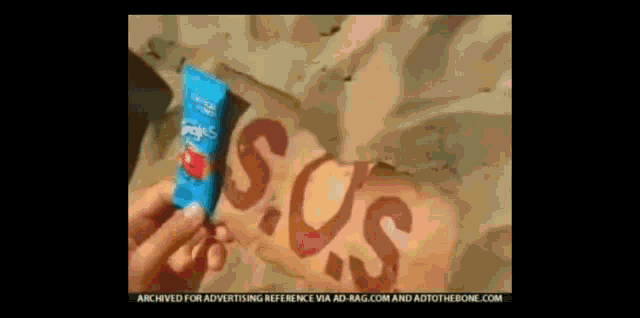 a person is holding a tube of sunscreen with the word sos painted on their leg