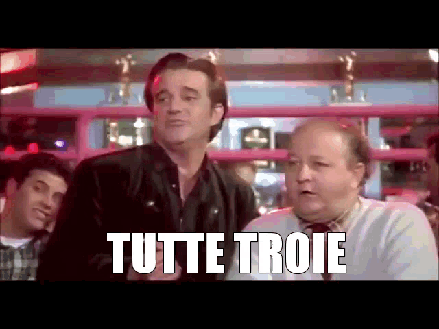 a group of men are standing in a boxing ring and one of them is saying tutte troie .