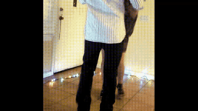 a man in a white striped shirt is standing next to another man in black pants