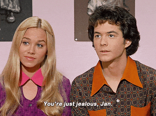a man and a woman are sitting next to each other and the woman is saying you 're just jealous jan
