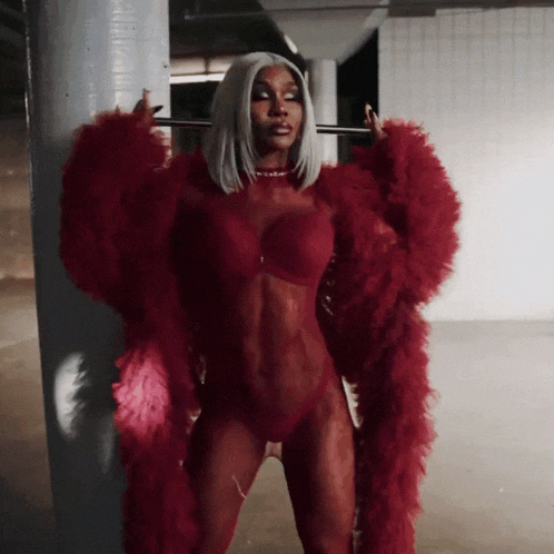 a woman in lingerie and a red fur coat is standing in a room