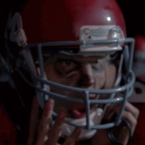 a close up of a football player wearing a red helmet