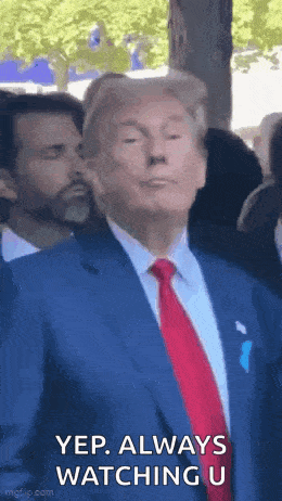 a man in a suit and tie is standing in front of a crowd of people .