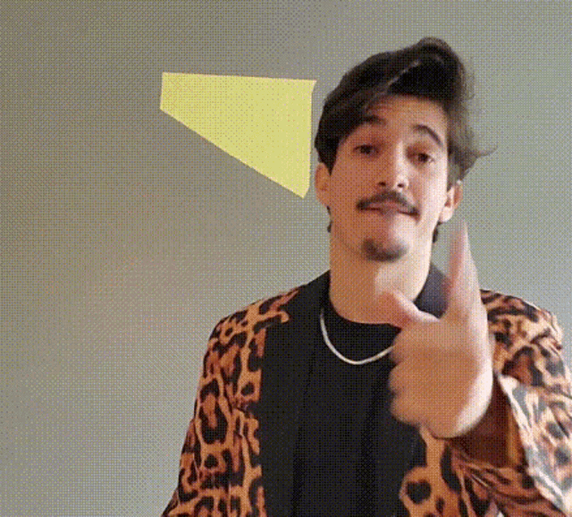 a man in a leopard print jacket is giving a thumbs up sign