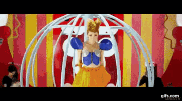 a woman in a colorful dress is in a cage with a gifs.com logo in the corner