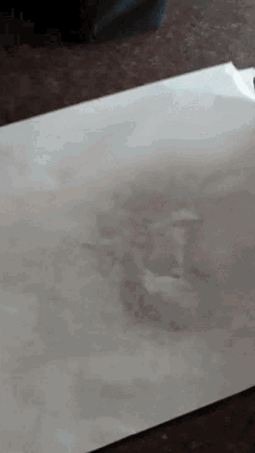a piece of white paper is laying on a brown table