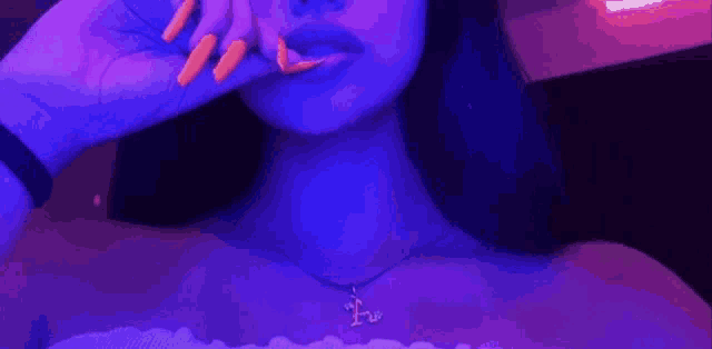 a woman with long orange nails is taking a selfie in a dark room .
