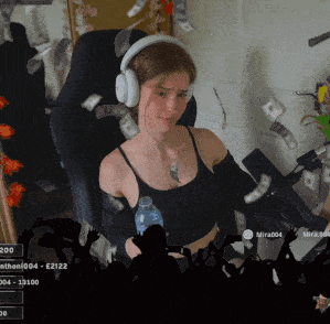 a woman wearing headphones sits in a chair with money falling on her