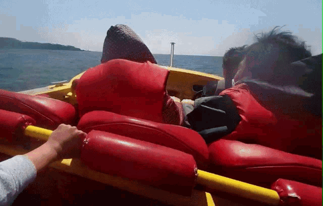 a yellow boat with red seats and a yellow oar