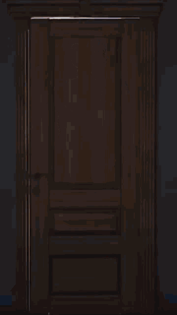 a woman in a black dress opens a door to a bedroom