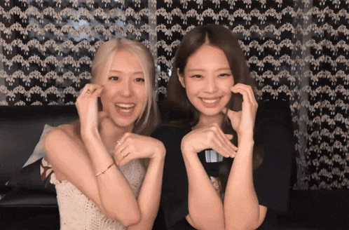 two women sitting next to each other with their arms crossed