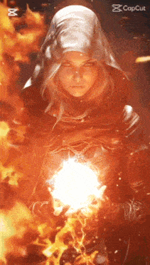 a woman in a hood is holding a sphere of fire