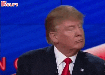 donald trump is wearing a suit and tie and making a funny face while giving a speech .