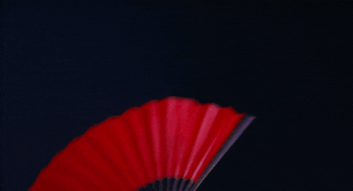 a woman holding a red fan in her hand