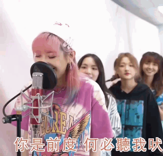 a girl singing into a microphone wearing a pink shirt that says regret