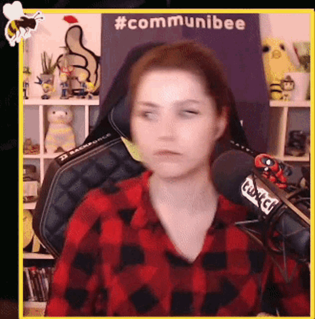 a woman sitting in front of a microphone with a sign that says communibee