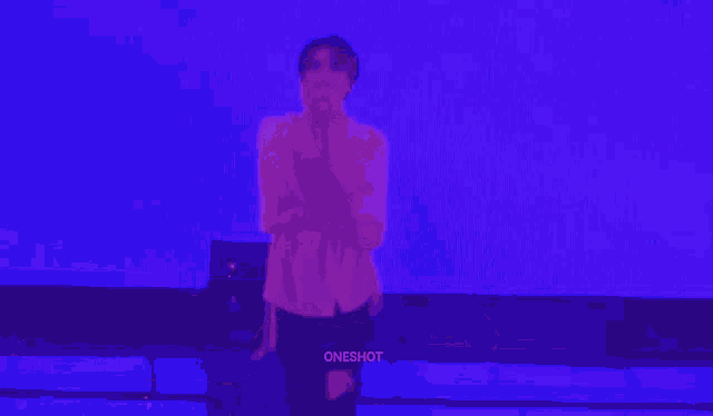 a man in a pink shirt is dancing in front of a purple background that says oneshot on the bottom