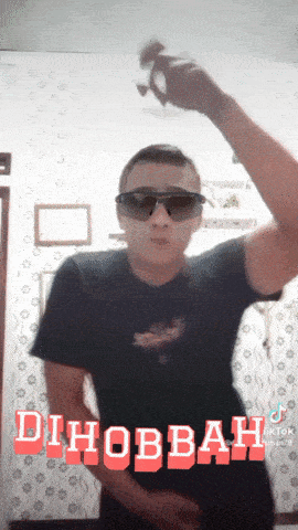 a man wearing sunglasses and a black shirt with the word dihobbah written on it