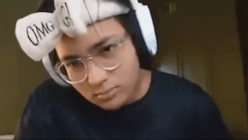 a man wearing glasses and a headband with the word omg written on it .