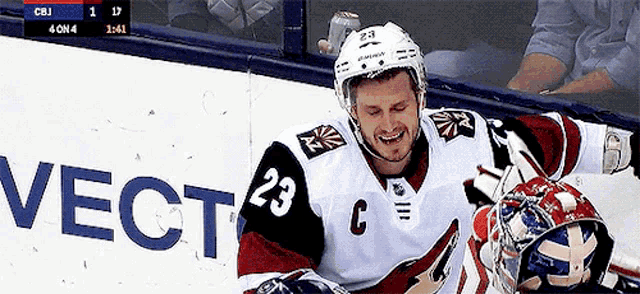 a hockey player with the number 23 on his jersey is smiling