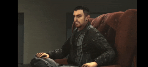 a man in a leather jacket is sitting in a chair and smiling