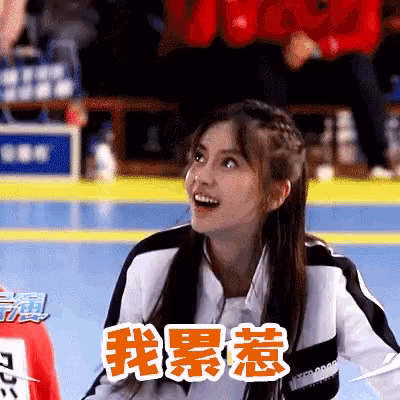 a girl with chinese writing on her shirt looks surprised