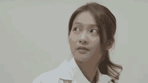a close up of a woman wearing a lab coat looking up .