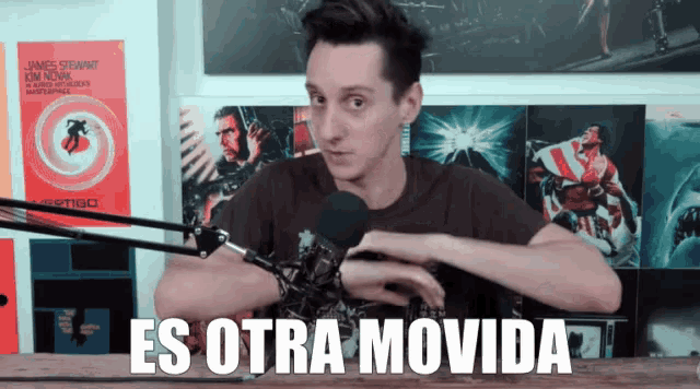 a man in front of a microphone with the words es otra movida