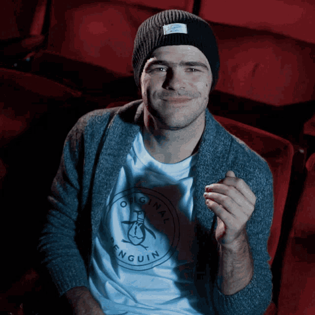 a man wearing a beanie and a penguin shirt