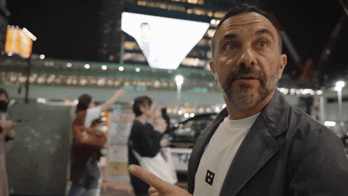 a man wearing a white shirt with the letter b on the front