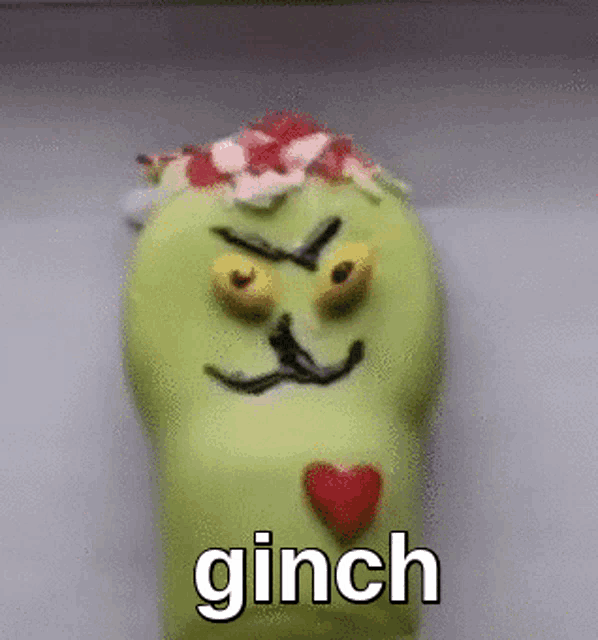 a green donut with a face drawn on it and the word ginch on it .
