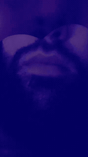 a close up of a man 's face with a purple background