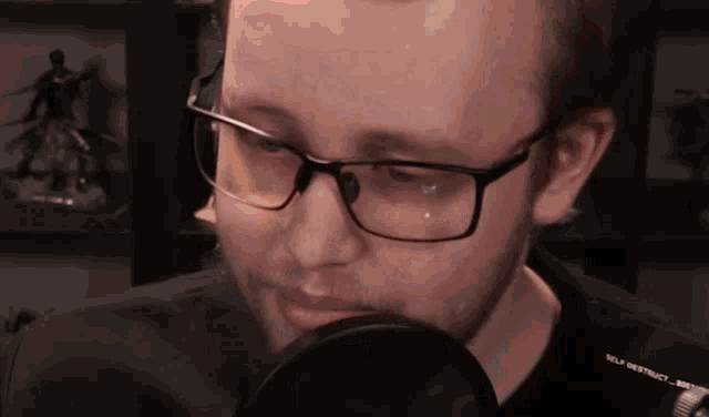 a man wearing glasses and a black shirt that says self destruct on it