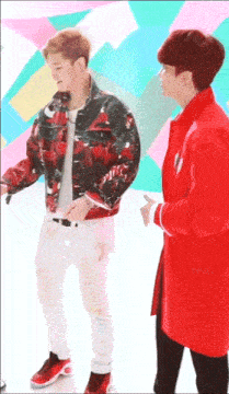a man in a red jacket stands next to another man in a red coat