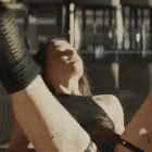 a woman wearing boxing gloves is stretching her legs .