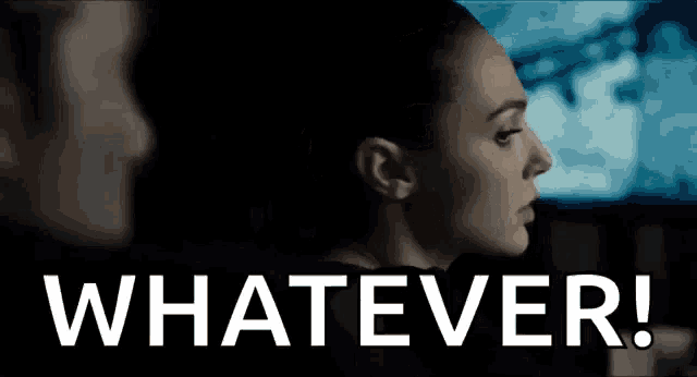 a woman is looking at a man in a dark room with the words `` whatever '' written in white letters .
