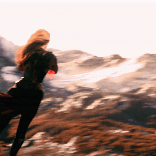 a blurry picture of a woman running through a field