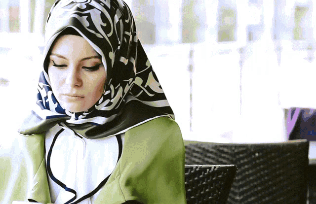 a woman wearing a scarf with arabic writing on it
