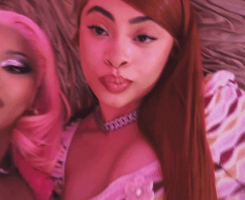 a close up of two women with pink hair