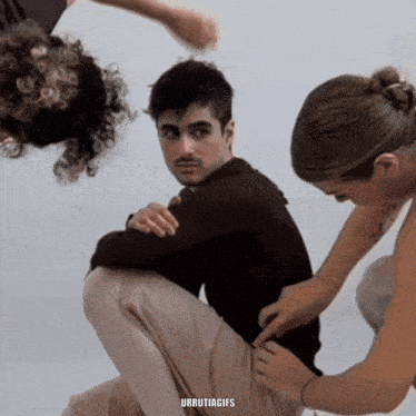 a man is being helped by two women and a url that says urrutiagies