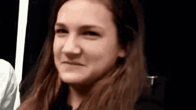 a close up of a woman making a funny face while looking at the camera .