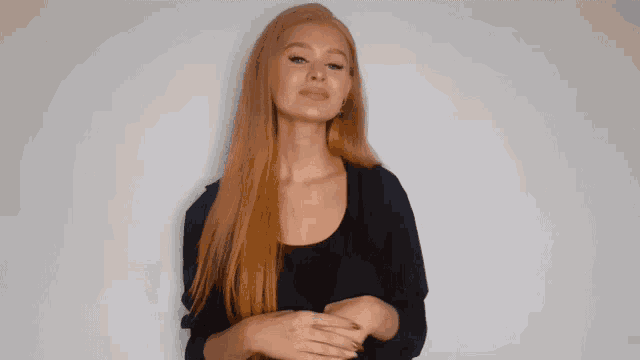 a woman with long red hair making a rude gesture