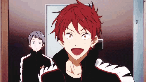 a man with red hair is standing next to another man in a locker room